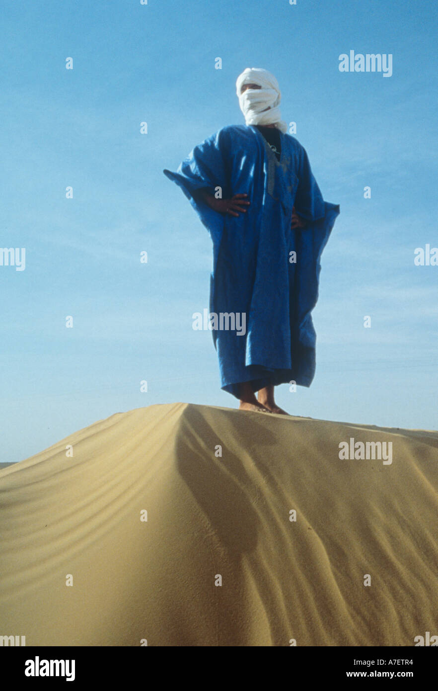Blu uomo in piedi su una duna di sabbia vicino a Merzouga nel sud del Marocco Foto Stock