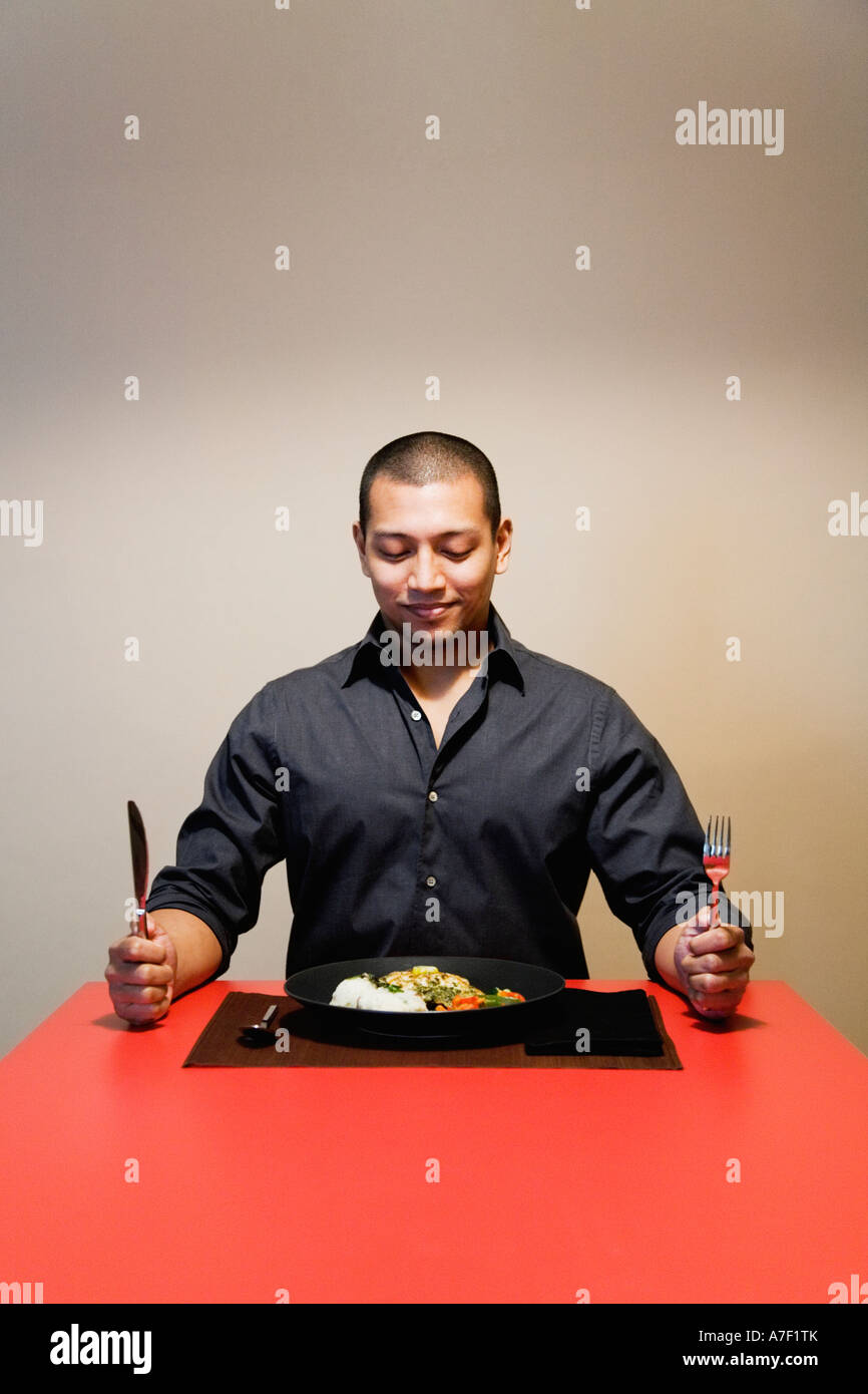 Uomo asiatico a tavola con piastra piena di cibo Foto Stock