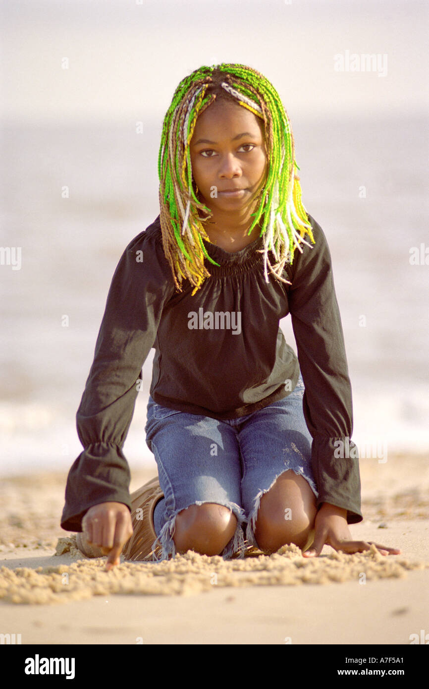 Giovane ragazza nera giocando in sabbia sulla spiaggia Foto Stock
