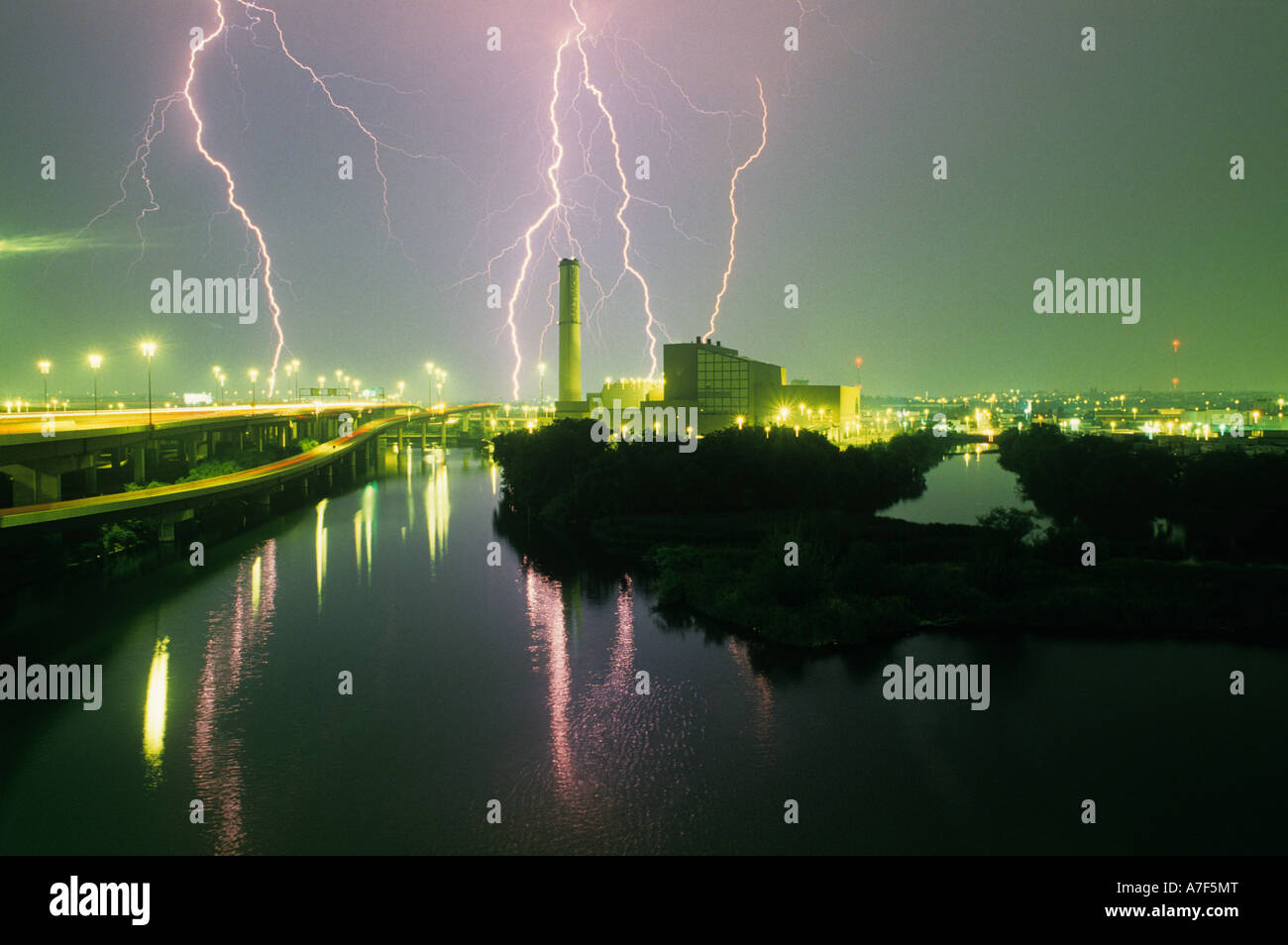 Stati Uniti Maryland Baltimore Summer Lightning tempesta su fumaiolo di fabbrica lungo il lungomare di notte Foto Stock