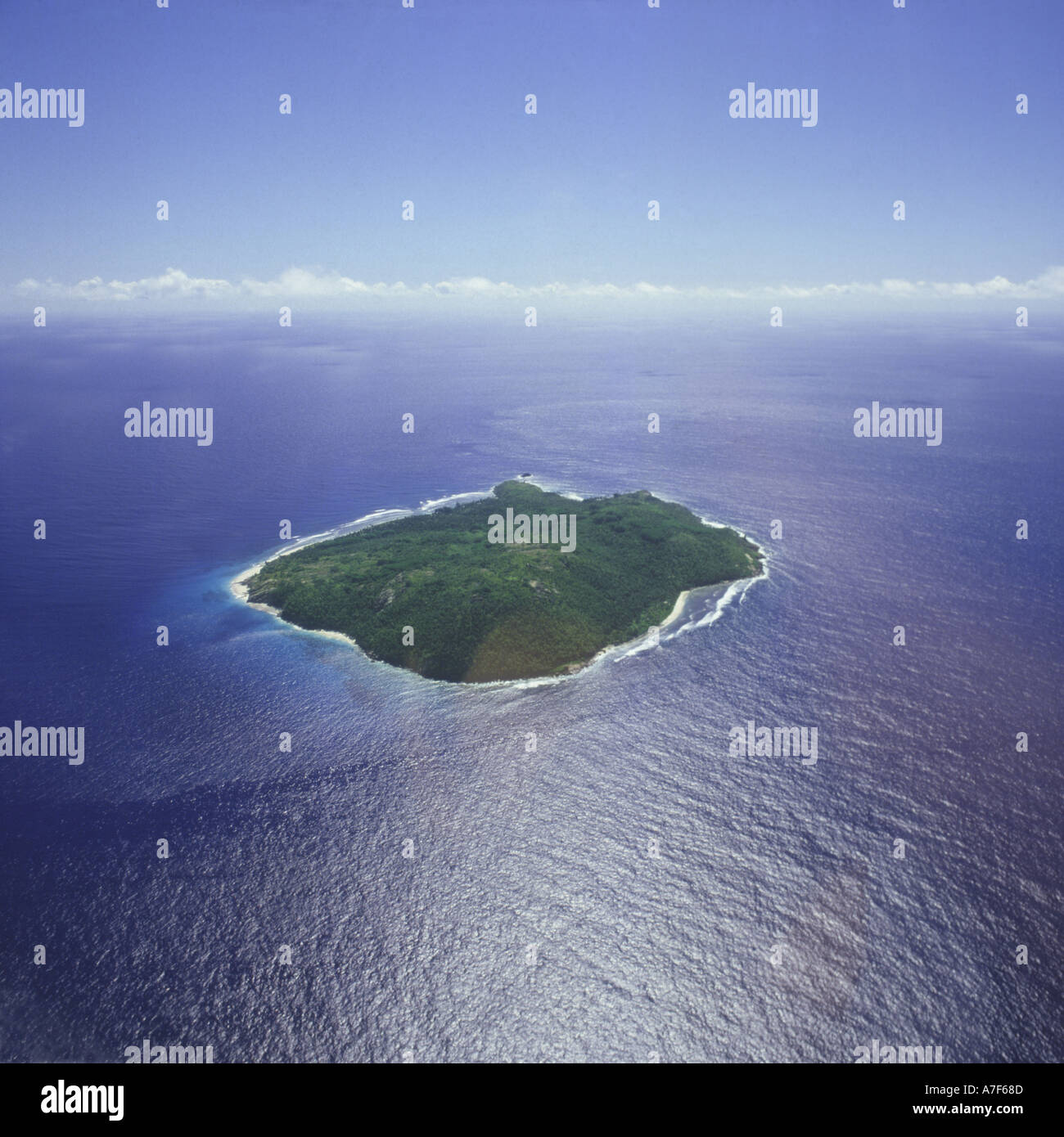 Vista aerea di alberi coperti isola deserta stile con spiagge bianche impostato in azzurro profondo oceano blu Frigate isola delle Seychelles Foto Stock