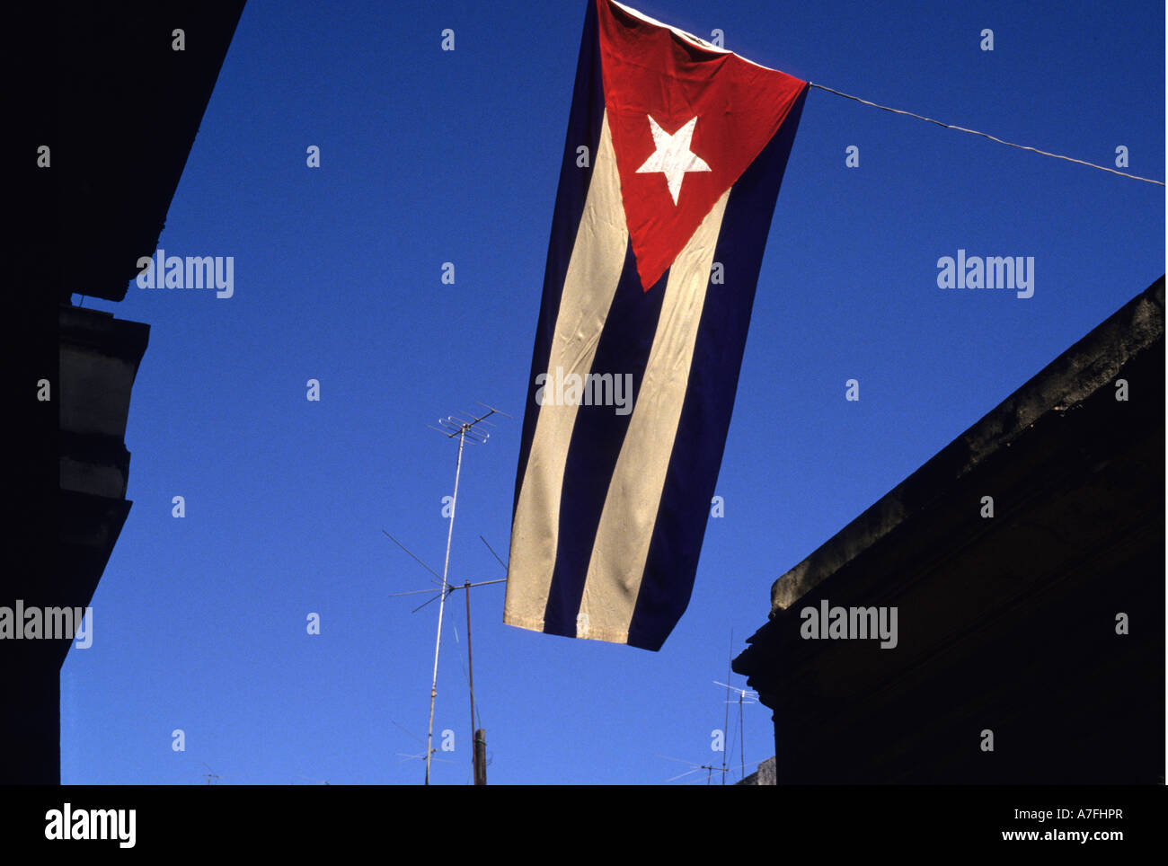 Cuba, La Habana.bandiera cubana che gravano su di una strada Foto Stock
