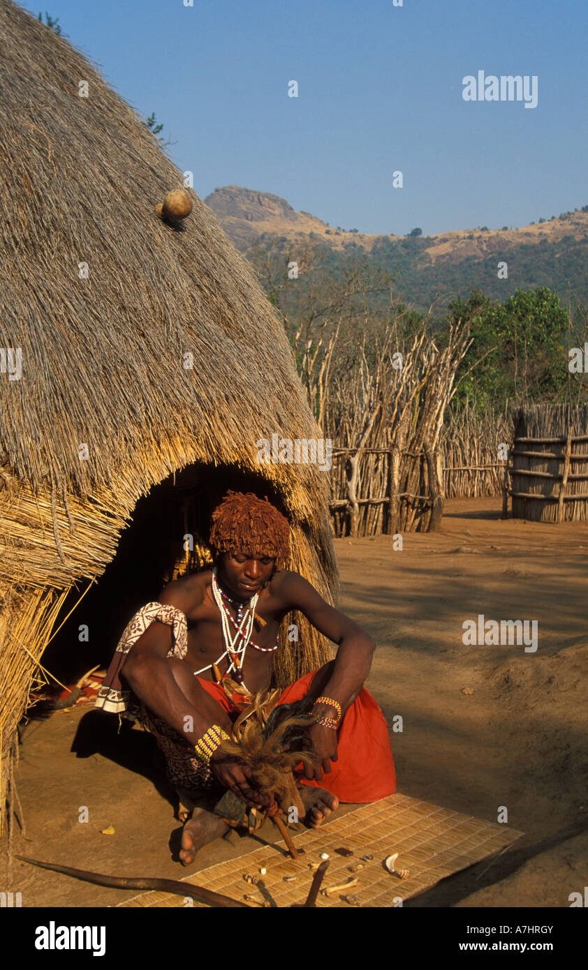 Sangoma gettando le ossa davanti al suo alveare hut mantenga villaggio dello Swaziland Foto Stock