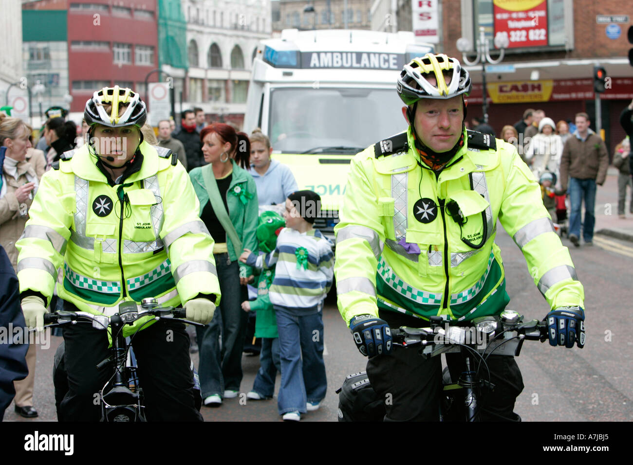 Due St John Ambulance bicicletta personale sul dovere con ambulanza dietro a seguire il il giorno di San Patrizio Foto Stock