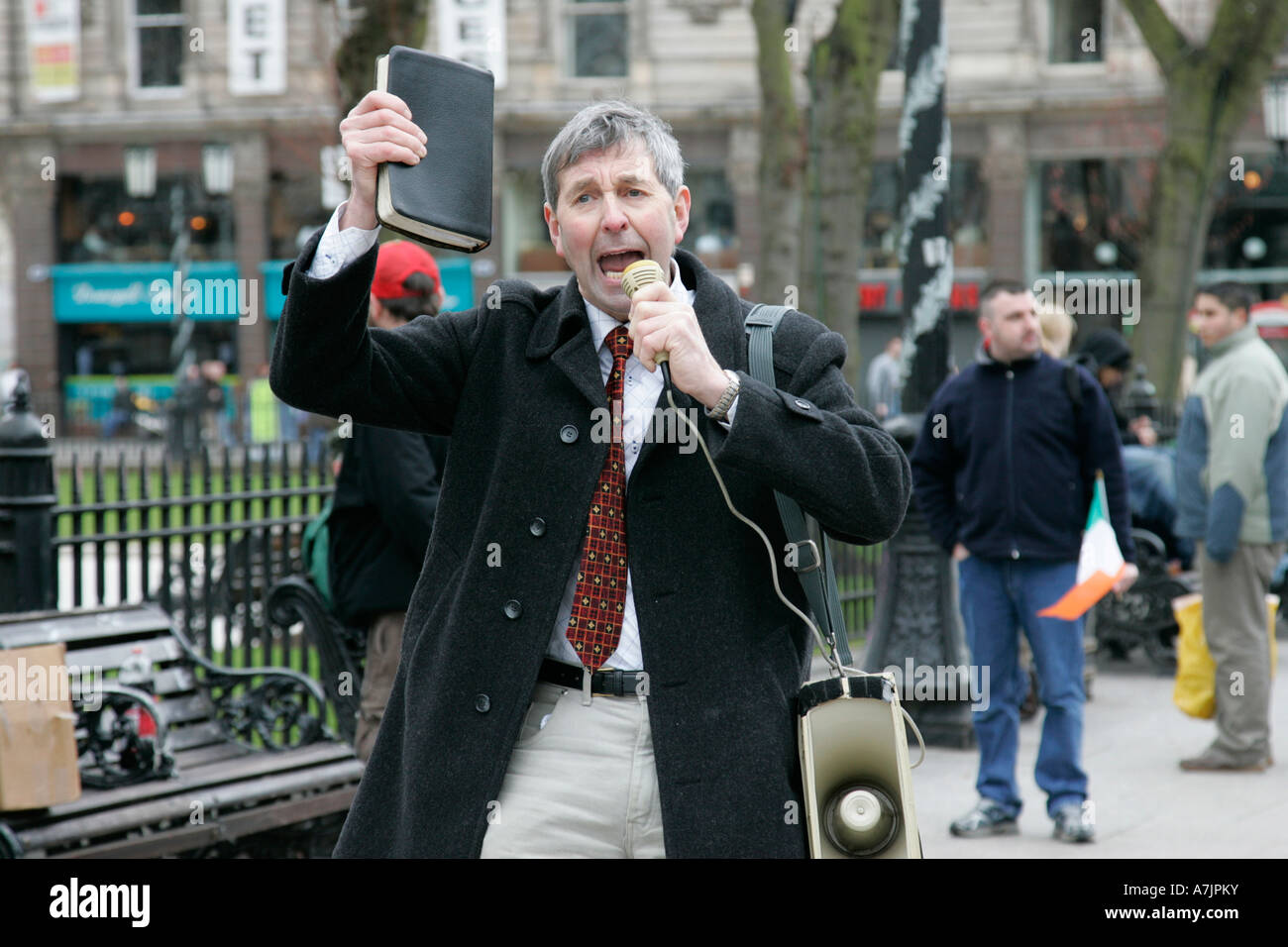 La Bibbia holding protester fornisce fuoco e zolfo predicazione paraders su il giorno di San Patrizio a Belfast City Centre Irlanda del Nord Foto Stock