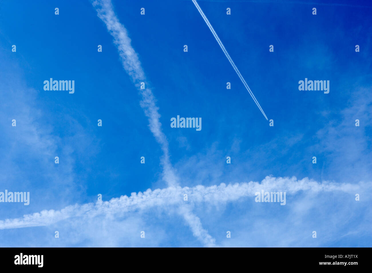 Velivoli a getto di scarico attraversa sentieri di cielo blu chiaro Foto Stock