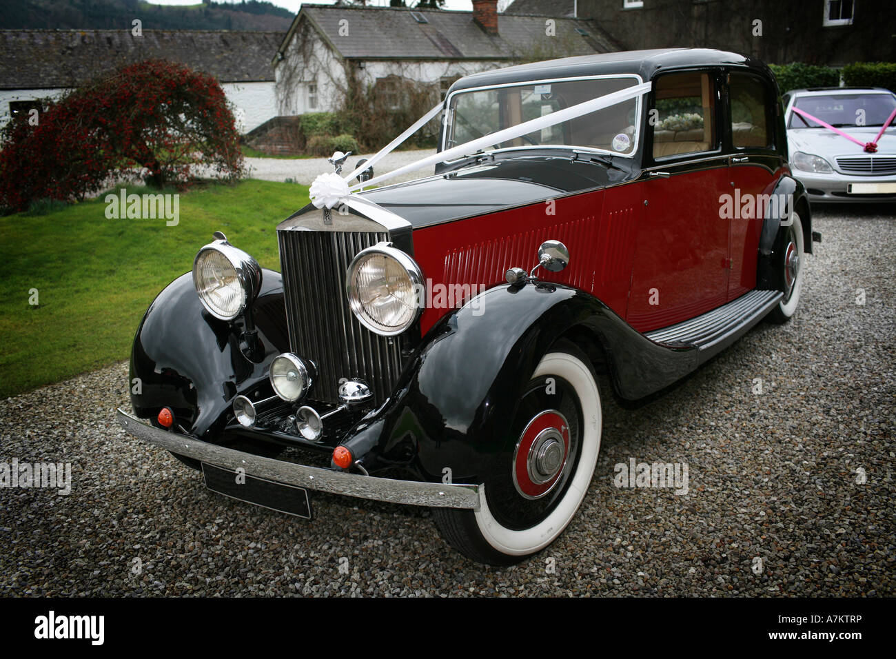 Rosso e nero vintage Rolls Royce auto nozze con il tipico nastro bianco decorazioni attende per gli sposi novelli sposi Foto Stock