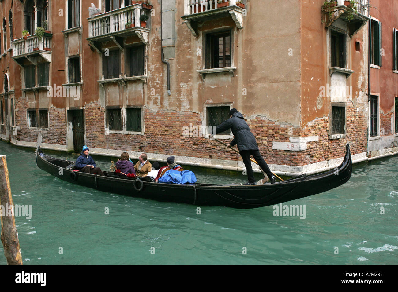 Un turista veneziano riempito Gondola barca negozia a novanta gradi angolo su un canal Venezia Italia Europa UE Foto Stock