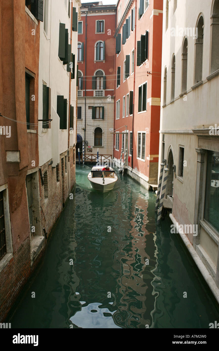 Un veneziano acqua taxi boat negozia a novanta gradi piegare in una tipica stretto canale Venezia Italia Europa UE Foto Stock
