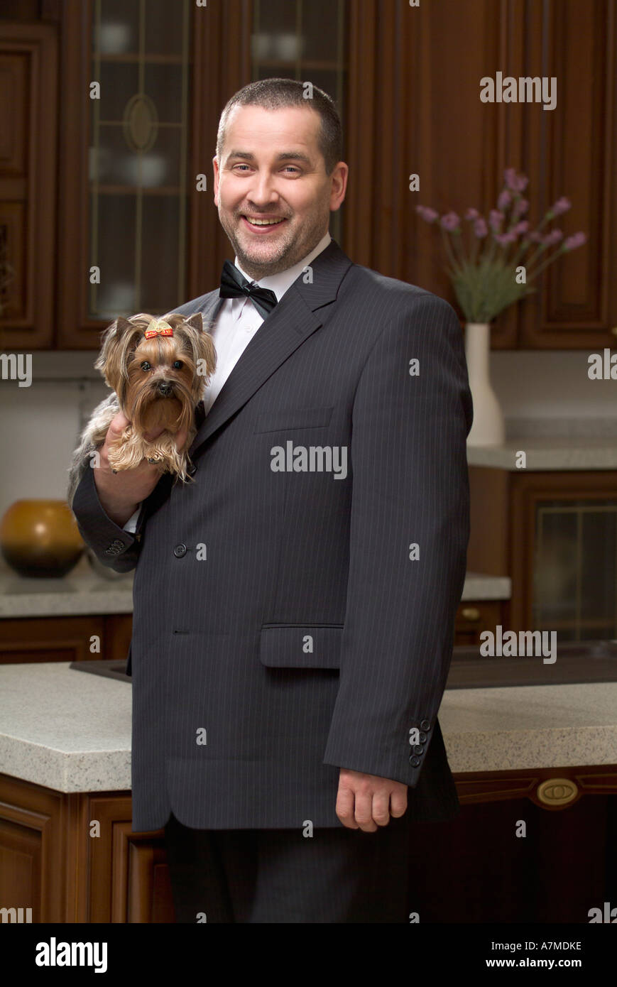 Uomo vestito con una tuta e tenendo premuto lap dog Foto Stock