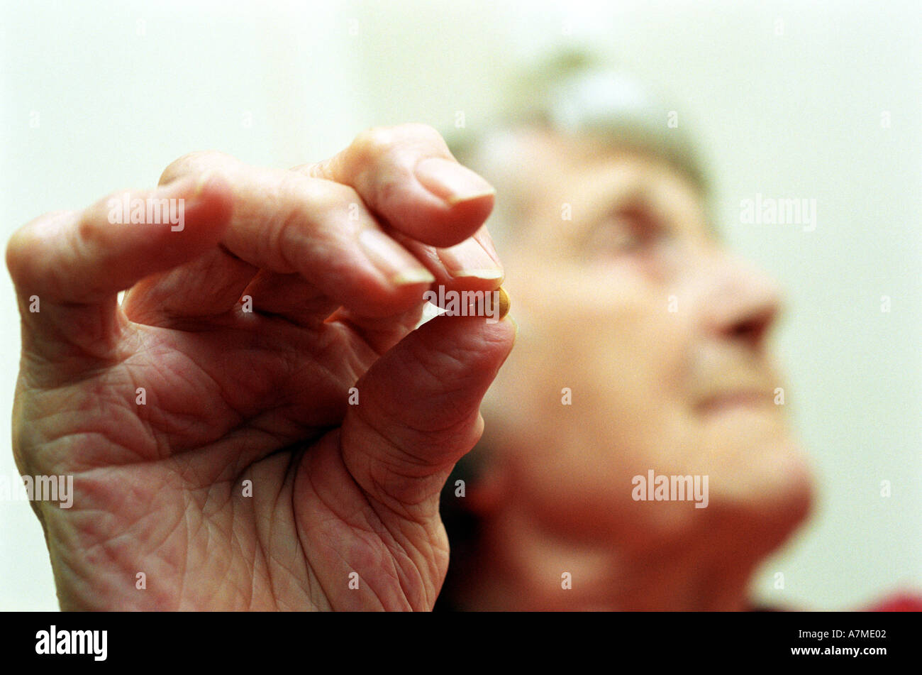 Artrite Close up di un signore anziane mano artritica tenendo la morfina tablet Foto Stock
