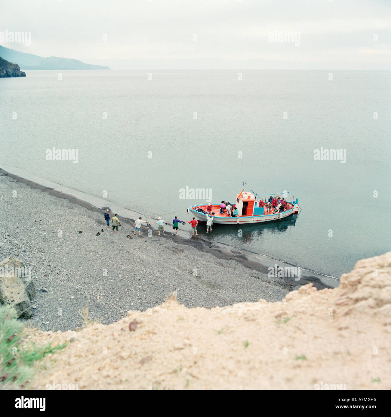 Un gruppo di persone di salire a bordo di un dipinto luminosamente barca Foto Stock