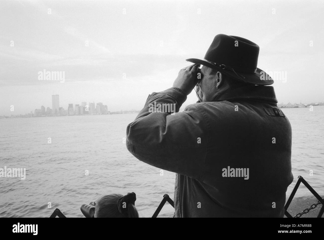 NA, USA, New York New York City. Uomo che utilizza un binocolo sulla Staten Island Ferry. Foto Stock