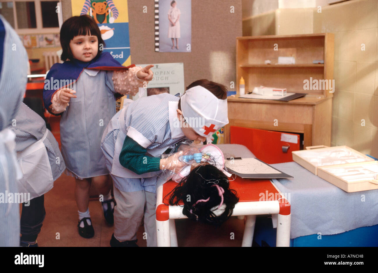 Bambini della scuola materna a giocare vestire in medico e infermiere uniformi Foto Stock