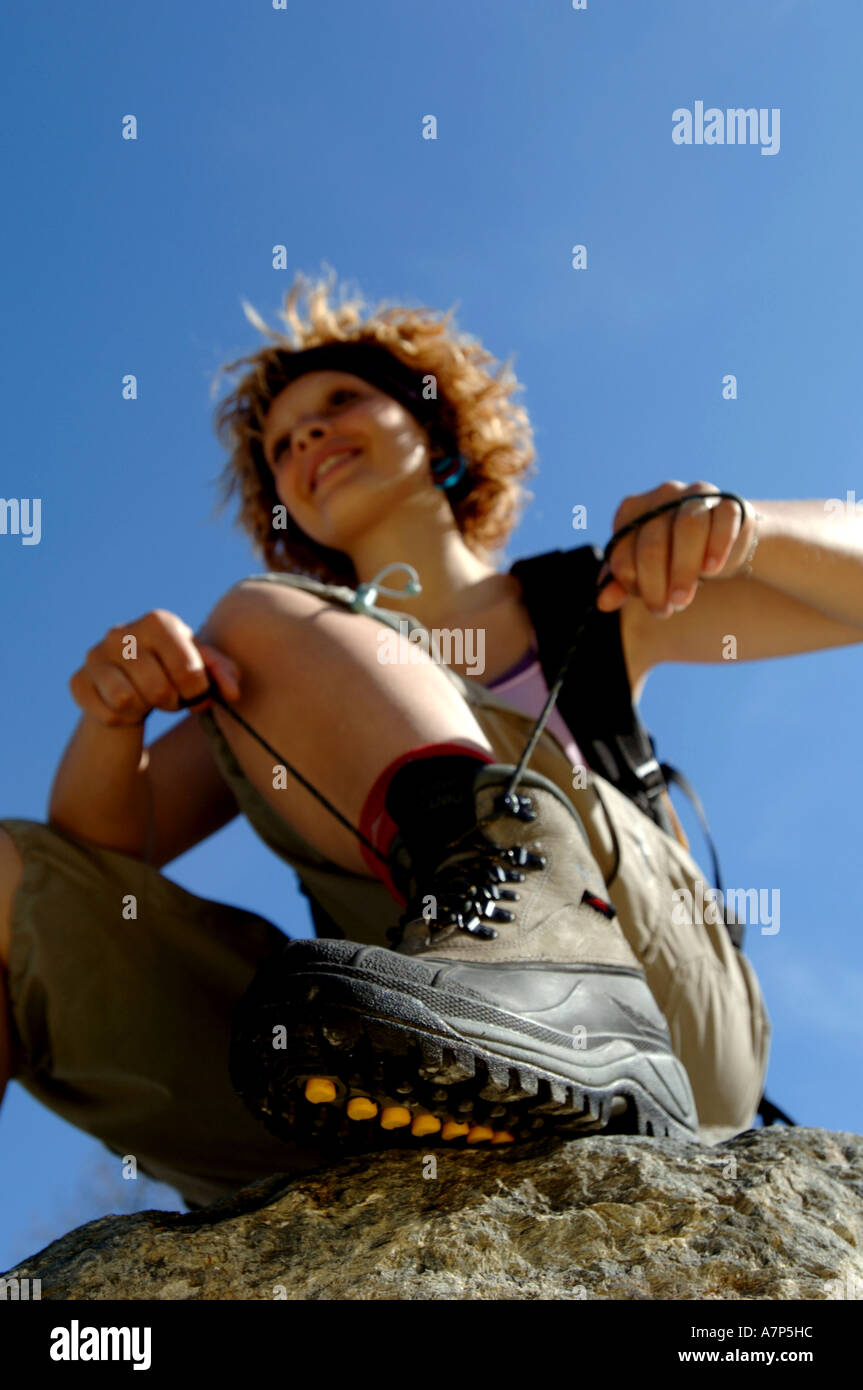 Giovane donna lega il suo scarpe da trekking, Francia Foto Stock