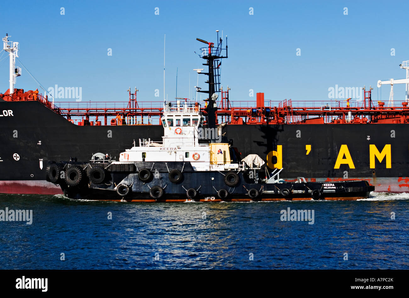 Industria di spedizione / petroliera di petrolio e un rimorchiatore a traino in assist.Porto di Melbourne in Australia. Foto Stock