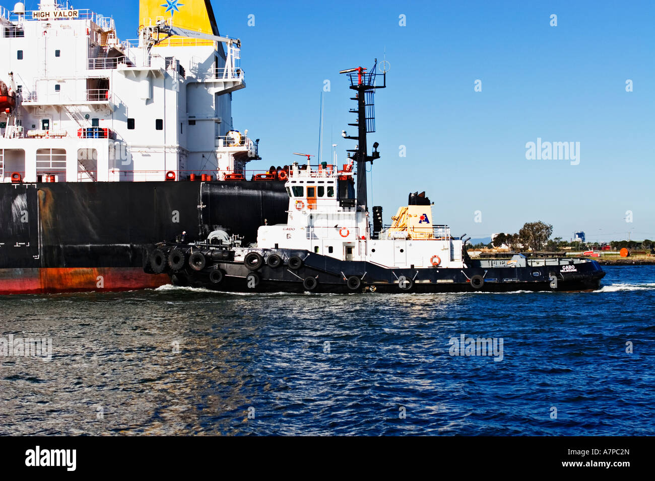 Industria di spedizione / petroliera di petrolio e un rimorchiatore a traino in assist.Porto di Melbourne in Australia. Foto Stock
