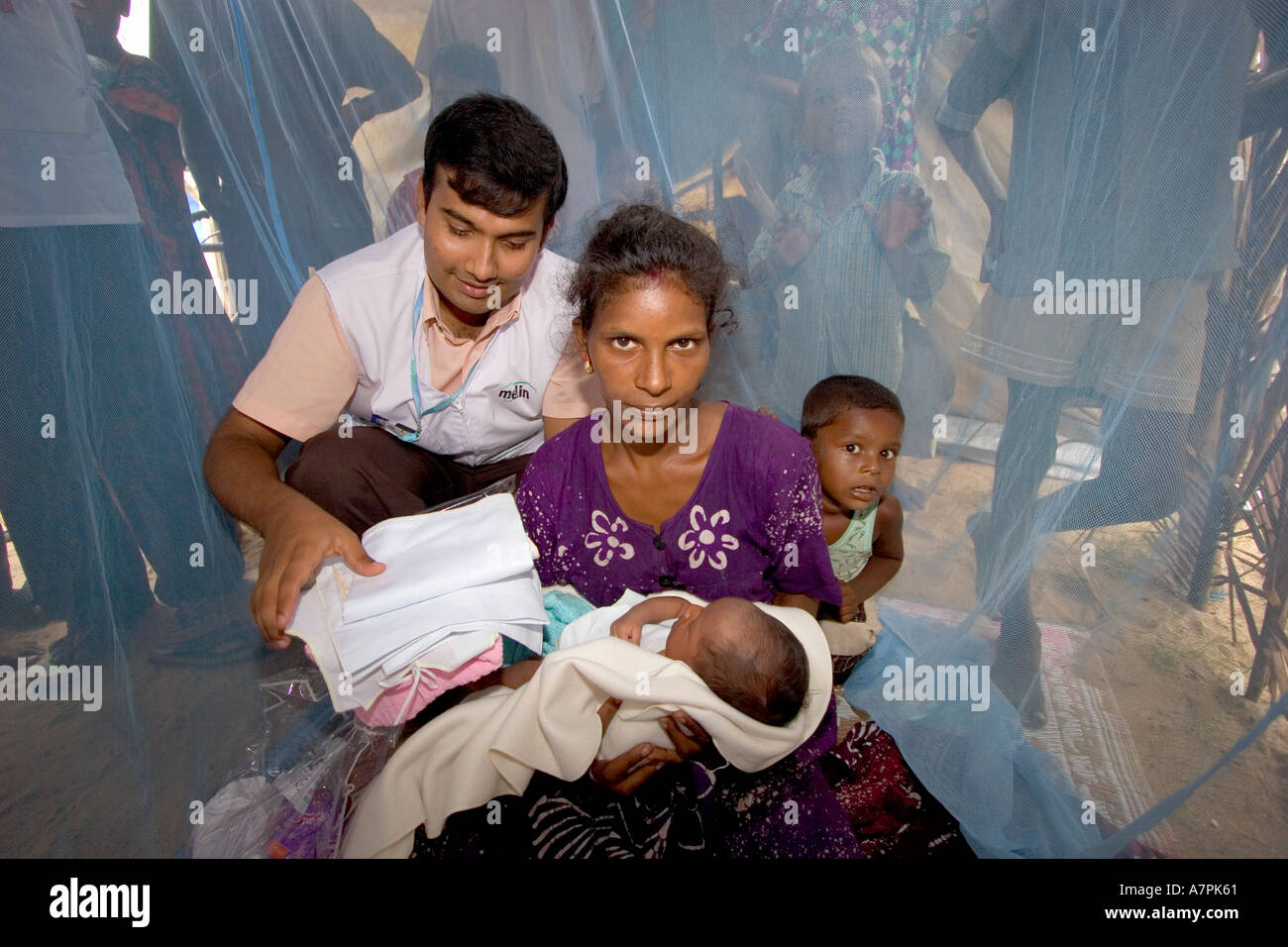 Dr Daniel dà Lakshmi e baby Gopikanth un Merlin baby kit a Ollikulum sfollati camp per le vittime dello Tsunami in Sri lanka Foto Stock