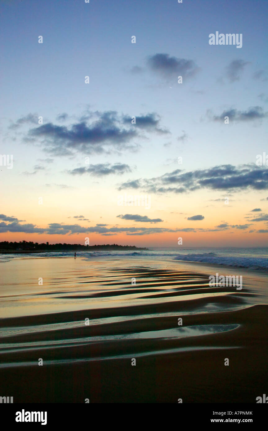 Costa del Mozambico al tramonto con il cielo e le nuvole riflettono in acqua lavato fino sulla spiaggia Barra Mozambico Foto Stock
