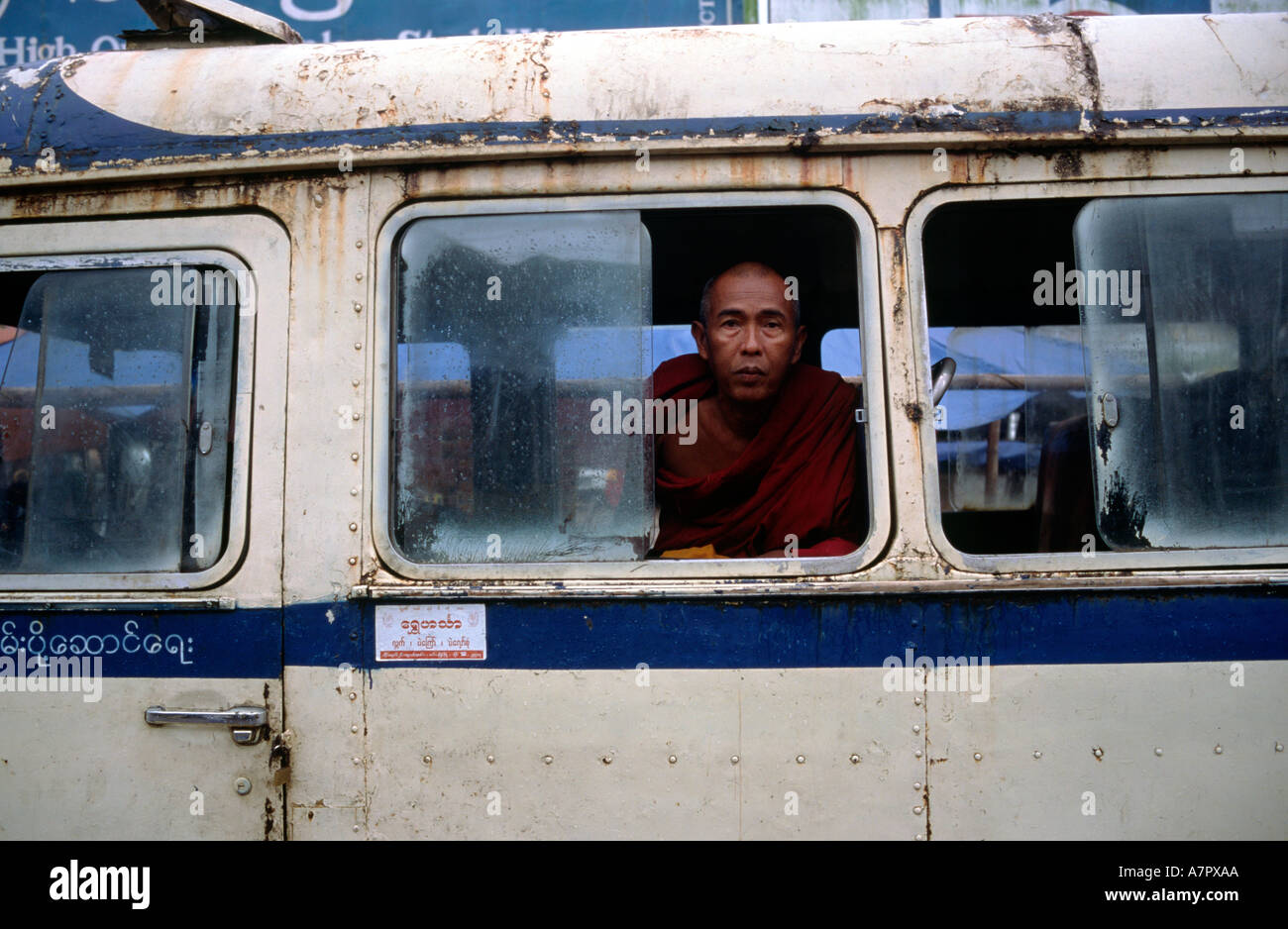 Lone monaco coetanei al di fuori di un bus inutilizzati in Mawlamyine Foto Stock