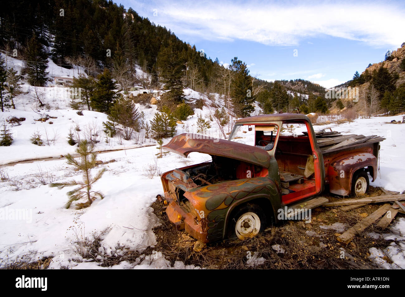 Rusty vecchia auto in aria aperta in Colorado USA nella neve e nel ghiaccio. Rotto il vecchio carrello nel paesaggio di marciume e ruggine Foto Stock