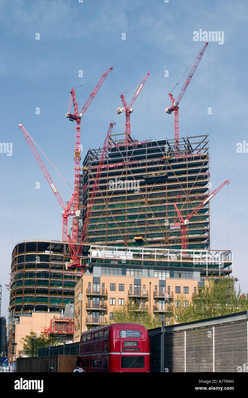Costruzione moderna di tall office block con il vecchio bus rosso a due piani Foto Stock