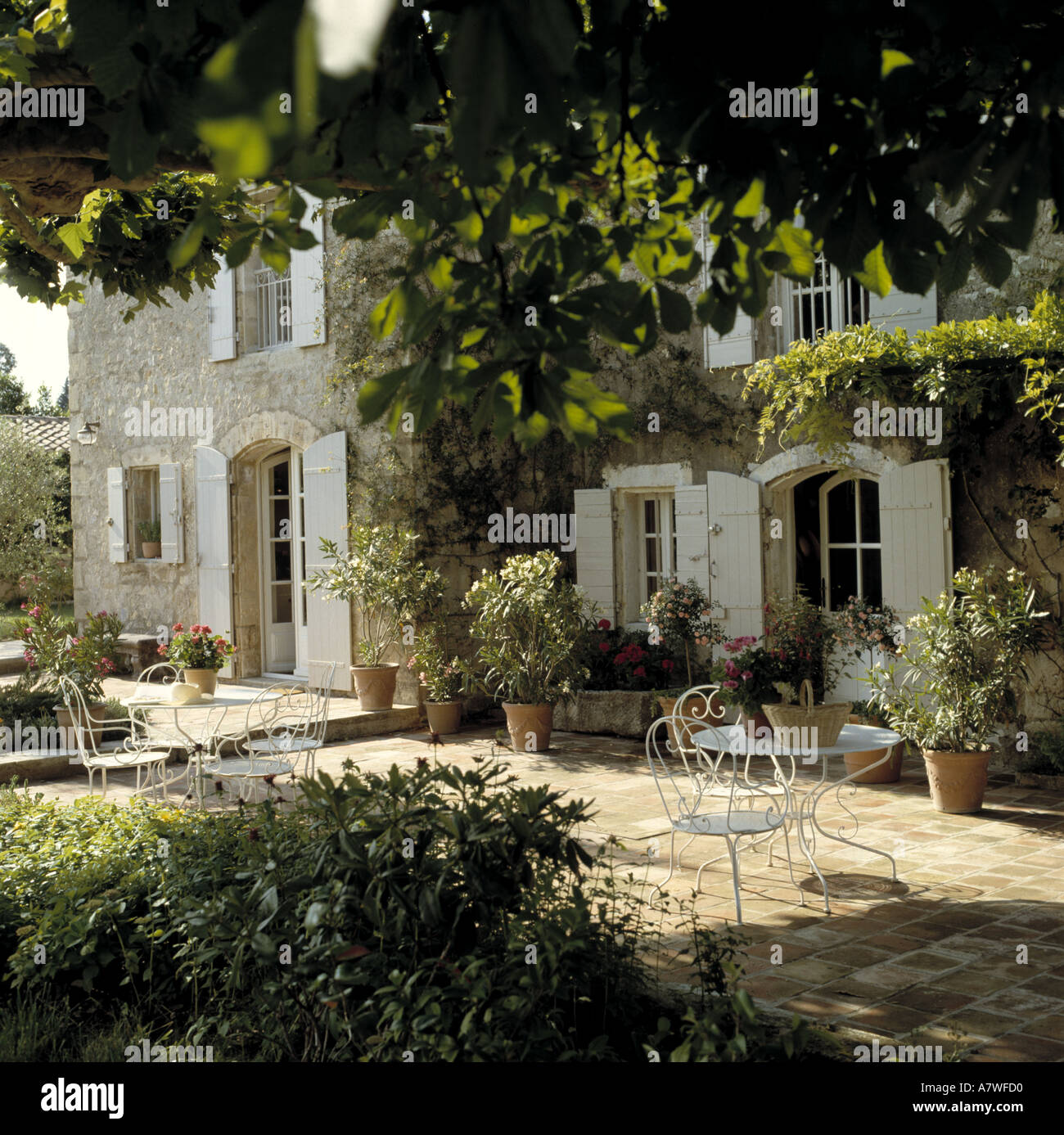 Soleggiato French country house con persiane bianche e patio in pietra Foto Stock