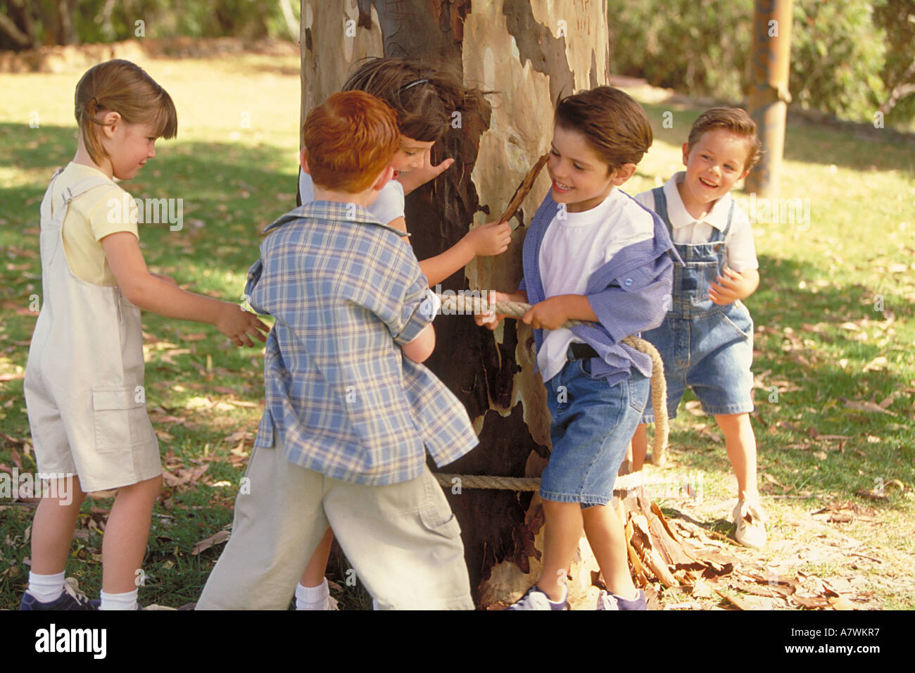Gruppo di bambini di legame con una ragazza di un tronco di albero Foto Stock