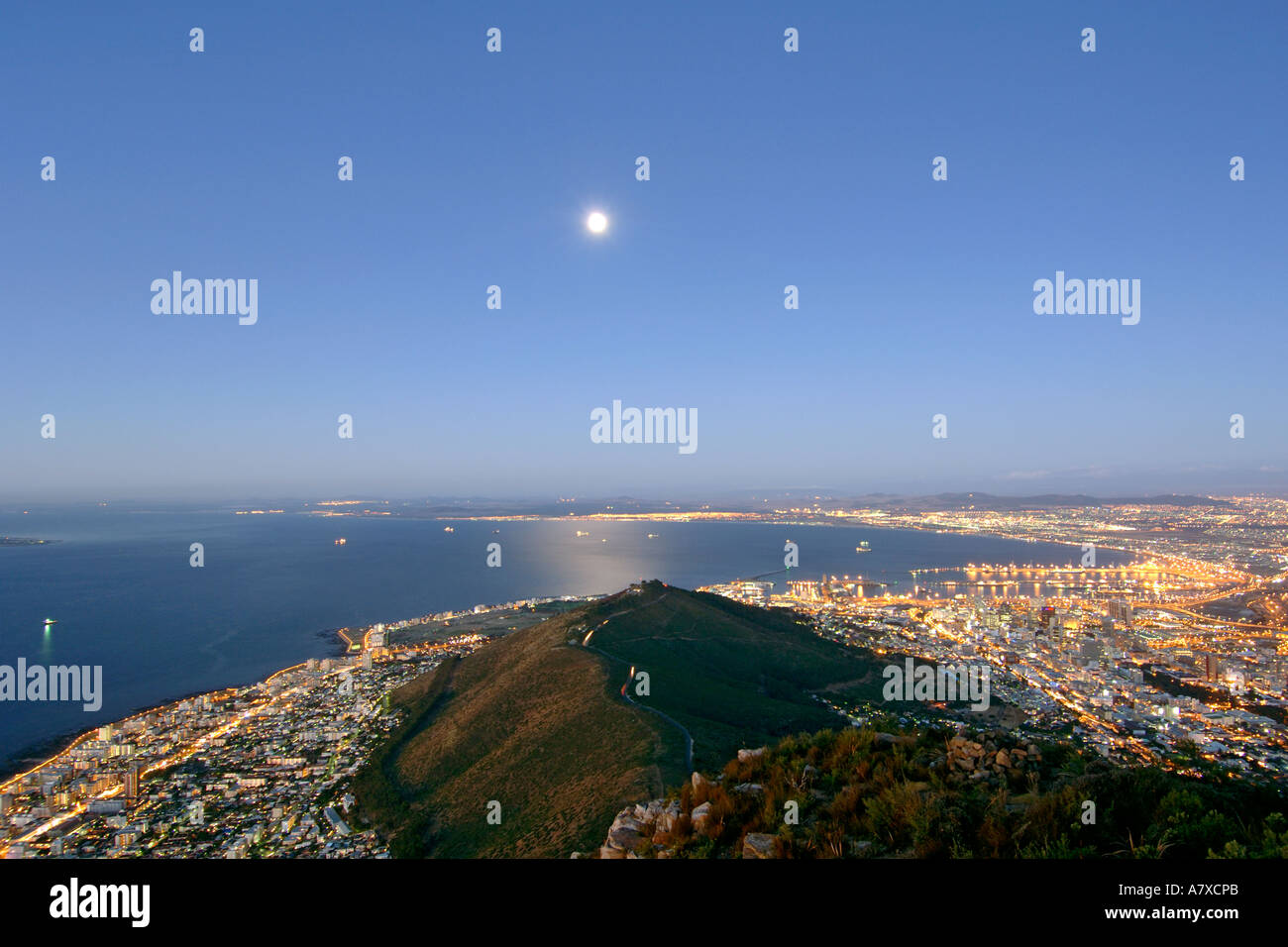Vista della città di Cape Town Signal Hill e la luna dal vertice della testa di leone al tramonto. La luna piena è visibile. Foto Stock