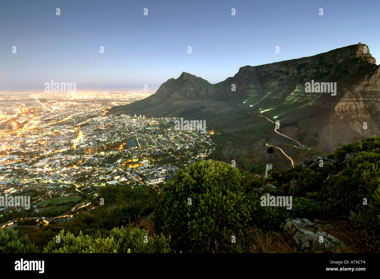 La Table Mountain e la città di Cape Town visto dalla cima della testa di leone al tramonto. Foto Stock