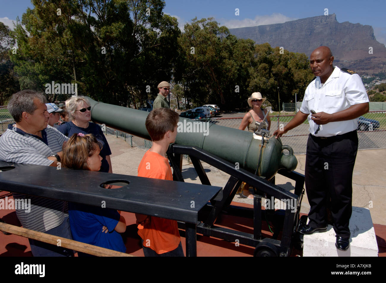 Chief Petty Officer Dudley malghe dando esplicativo parlare a fianco del cannone di mezzogiorno il cannone a Cape Town, Sud Africa. Foto Stock