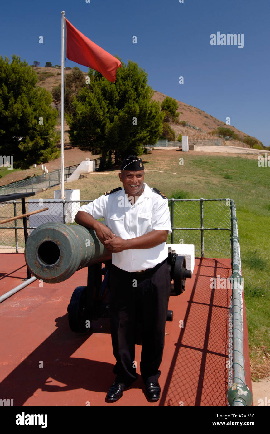 Chief Petty Officer Dudley malghe in posa a fianco del cannone di mezzogiorno il cannone a Cape Town. Foto Stock
