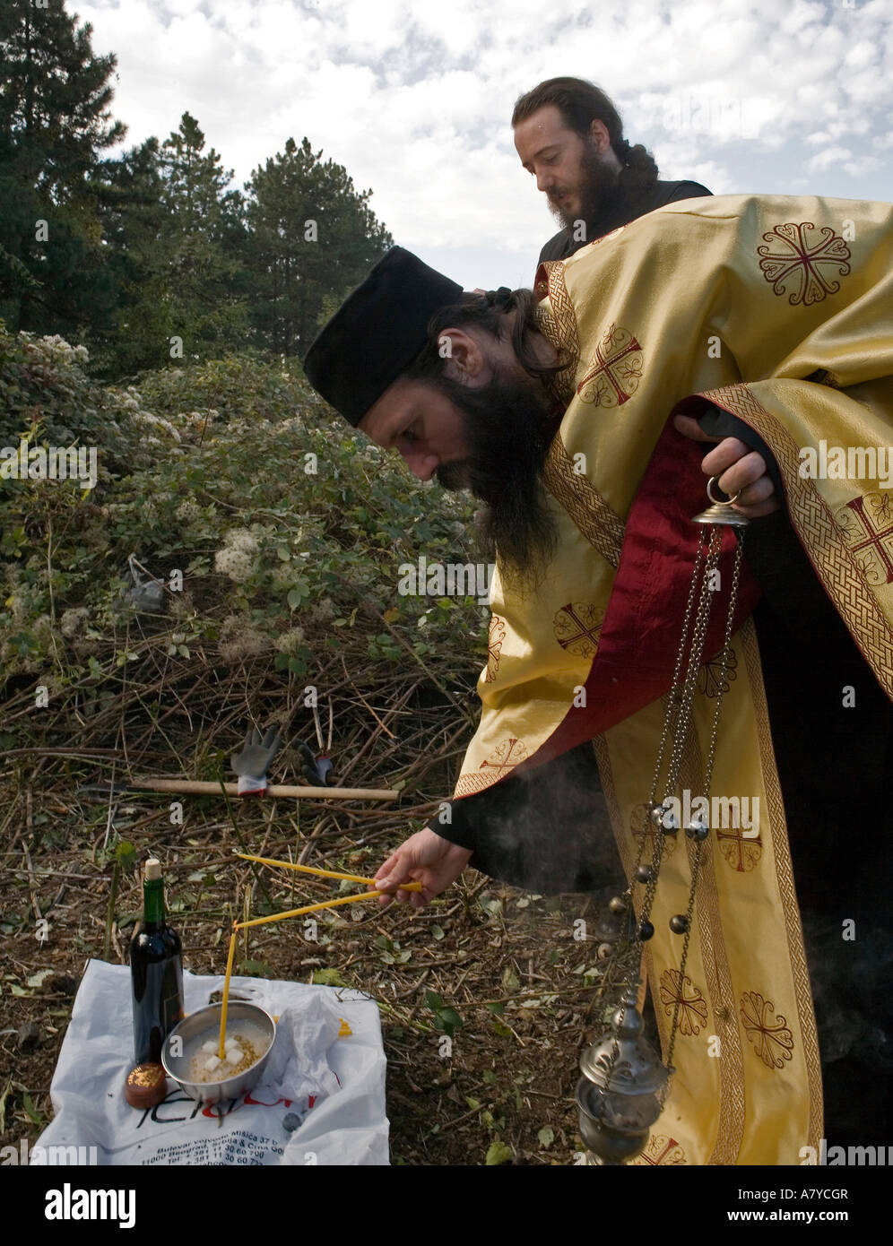 Serbo un sacerdote ortodosso Padre Atanasije visita la tomba di sua madre. - Non può essere utilizzato in diffamazione nei confronti della Serbia. Foto Stock