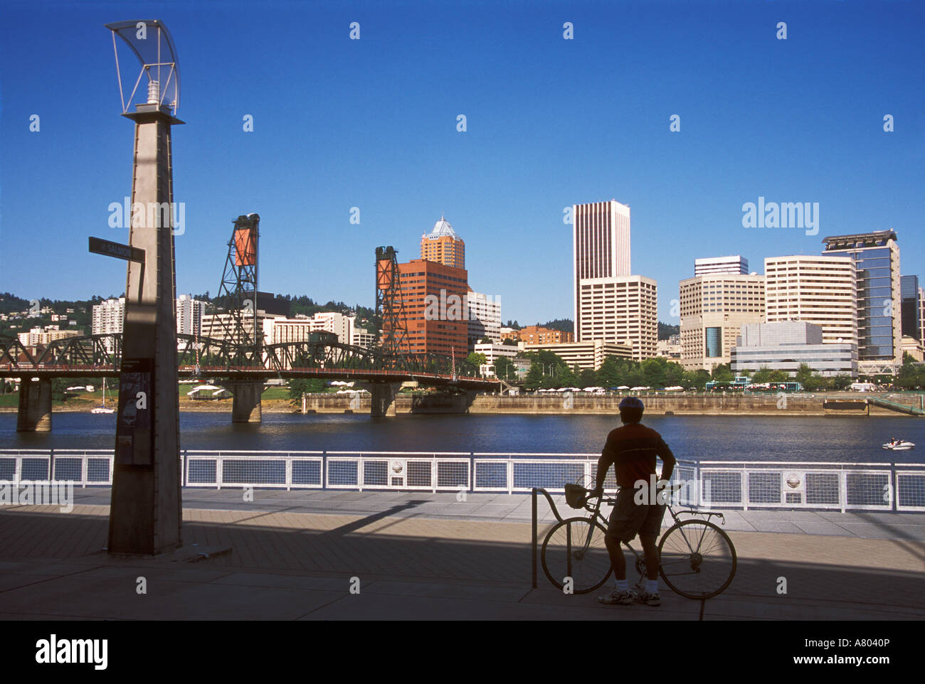 Un ciclista in piedi sulla vera Katz Eastbank spianata sulla sponda est del fiume Willamette Foto Stock