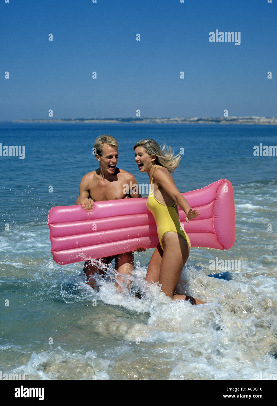 Coppia con lilo in surf Foto Stock