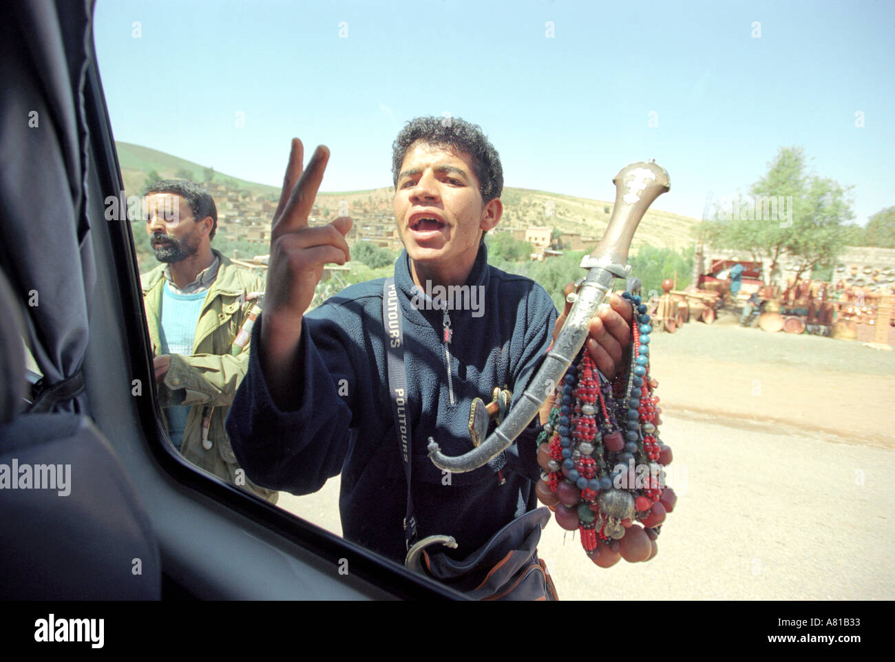 Venditore ambulante che cerca di vendere al turista in Marocco, street o venditori ambulanti vendono regali e souvenir per i turisti Foto Stock