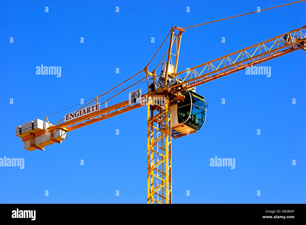 Tall gru su un sito di costruzione con un luminoso cielo blu. Foto Stock