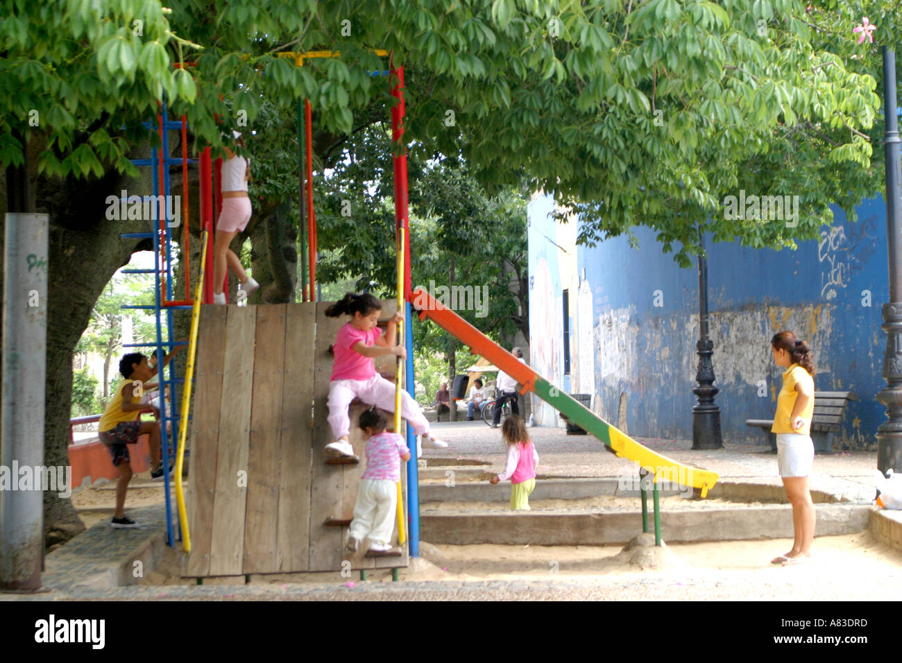 Bambini che giocano su aslide e oscilla in Caminito, La Boca, Buenos Aires Foto Stock
