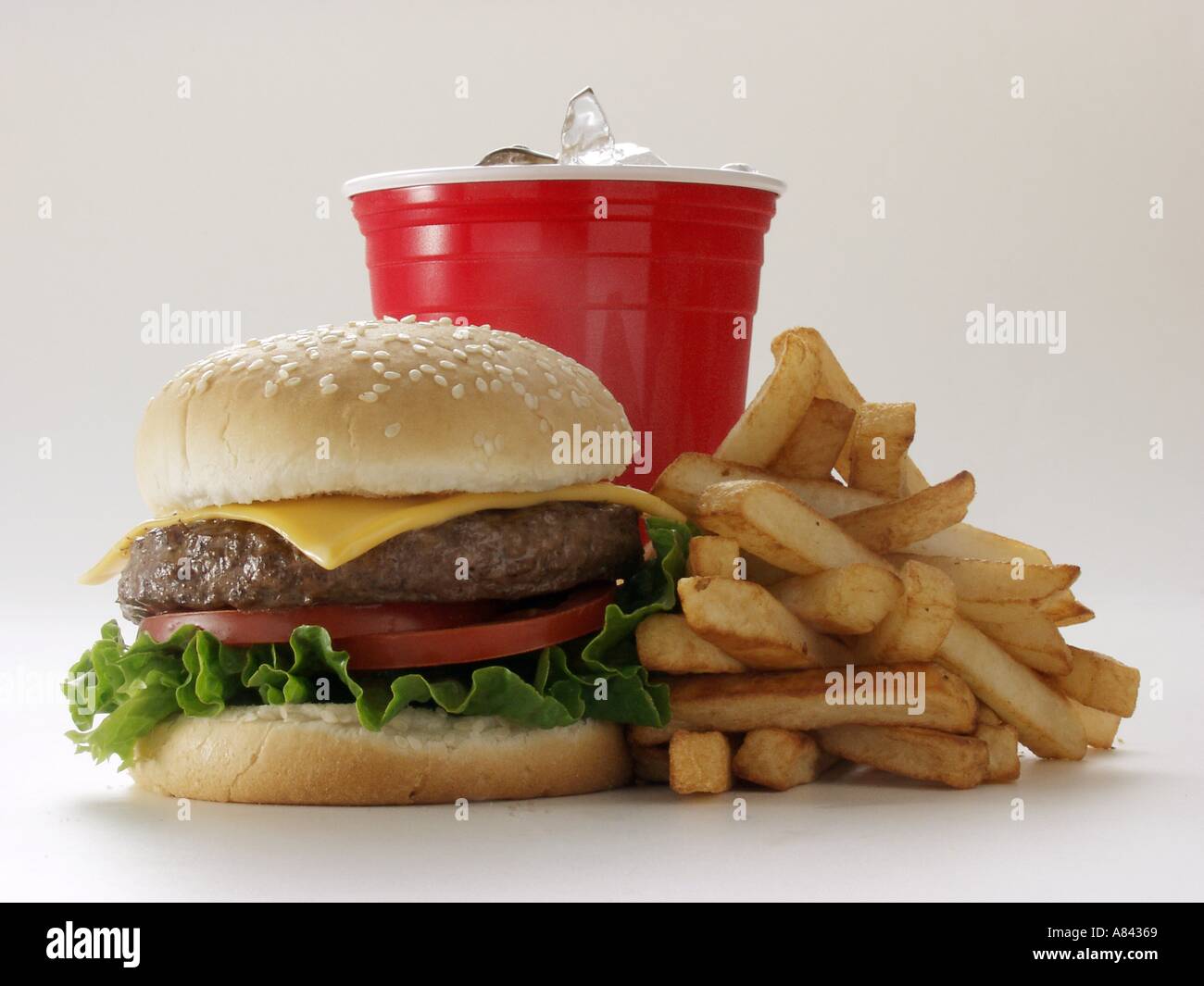 Un Cheeseburger con patate fritte e una bevanda Foto Stock