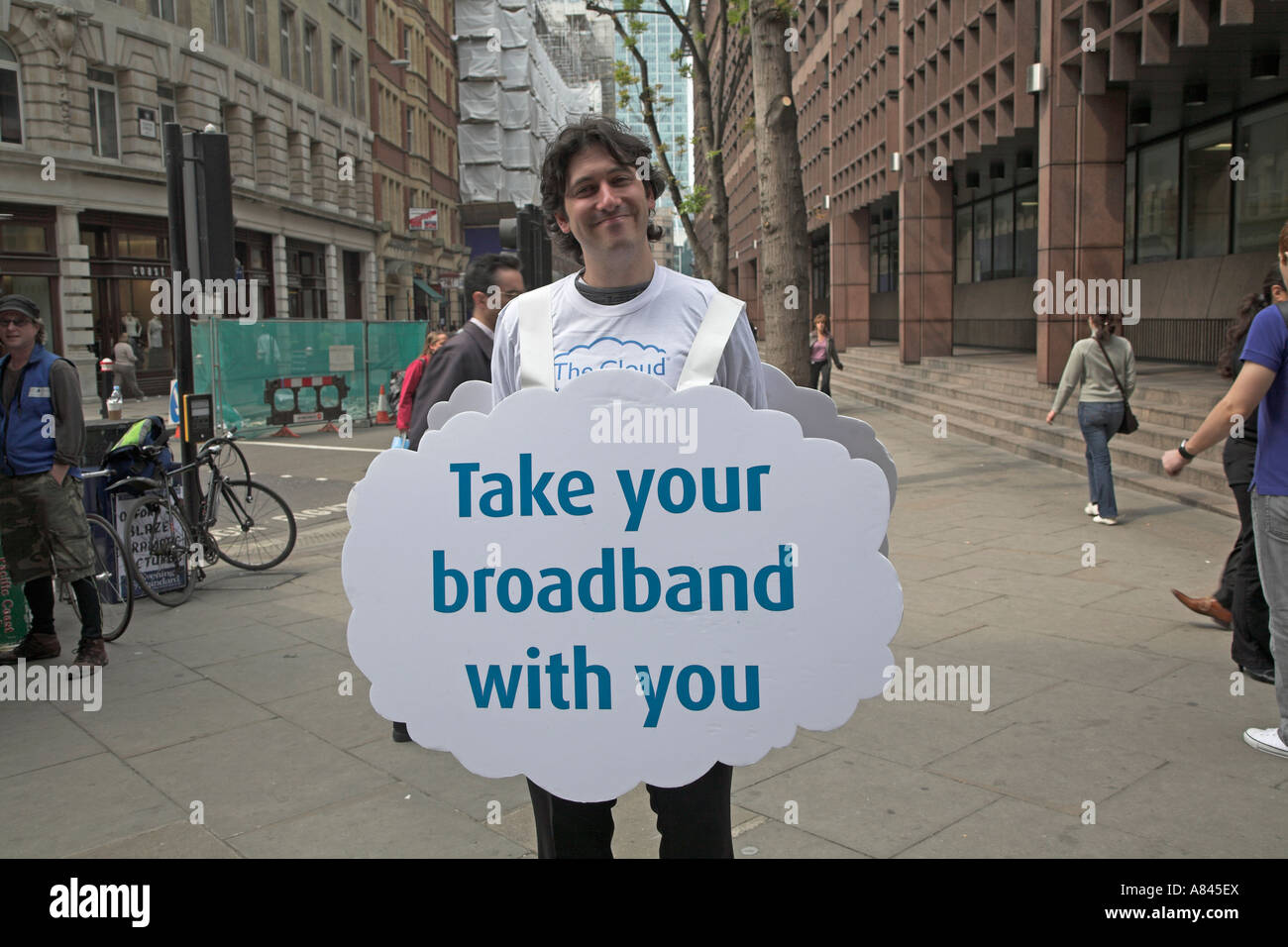 Uomo sorridente azienda pubblicità scheda sandwich per il Cloud internet a banda larga, Londra, Inghilterra Foto Stock Uomo sorridente azienda pubblicità scheda sandwich per il Cloud internet a banda larga, Londra, Inghilterra Foto Stock