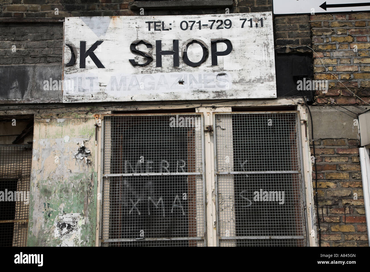 Derelitti chiuso ex adulto book shop East End di Londra con Merry Xmas graffiti Foto Stock