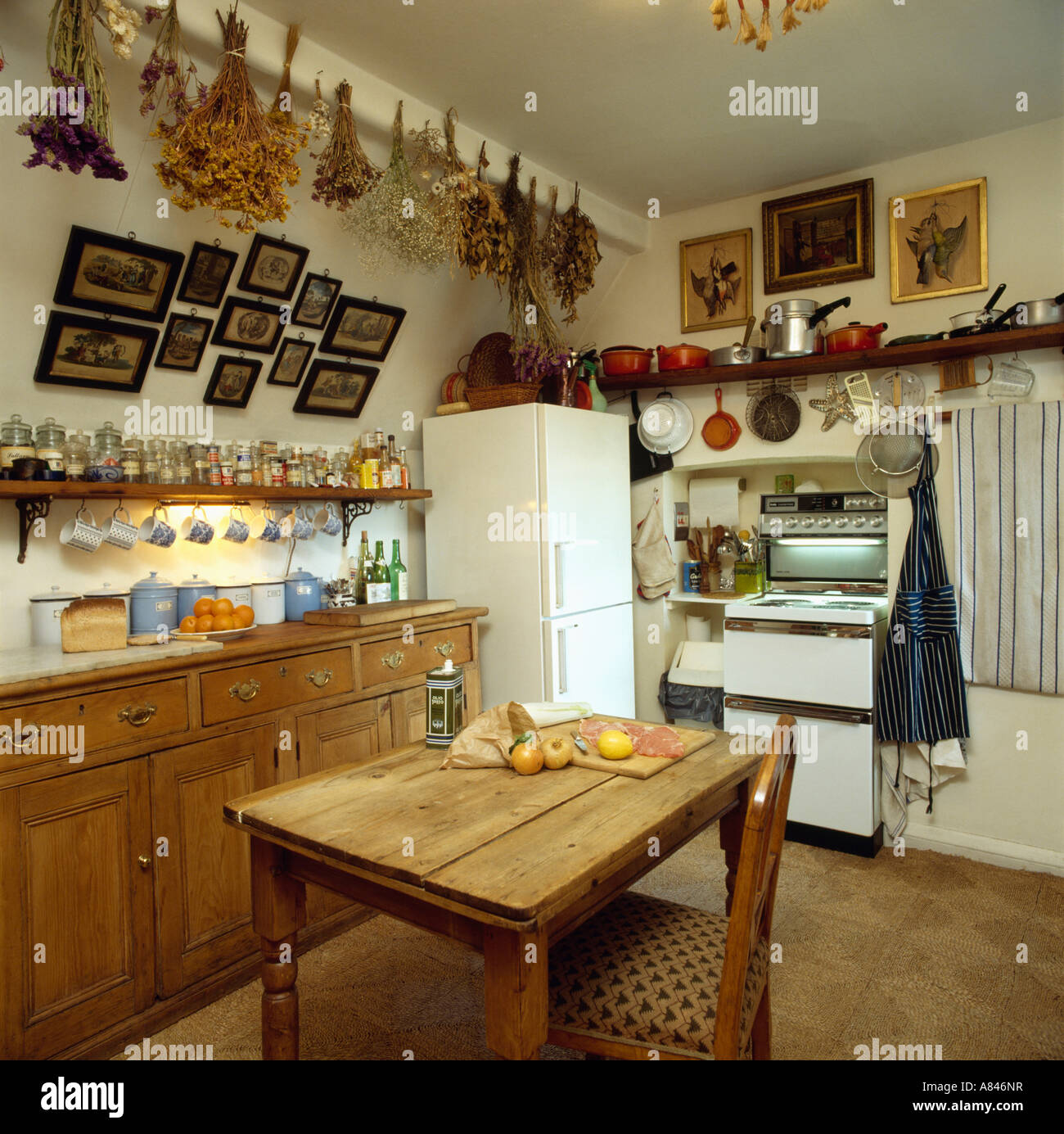 Tabella di pino e da bancone frigorifero e forno in mansarda piccola cucina  con fiori secchi pendenti dal soffitto Foto stock - Alamy