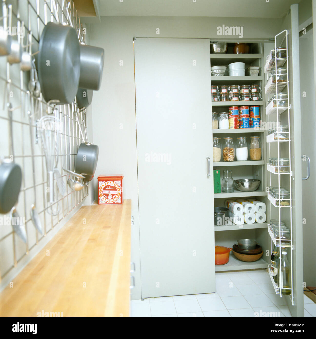 Aprire lo sportello di armadietto dispensa con ripiani in cucina galley con  pentole su rack in metallo Foto stock - Alamy