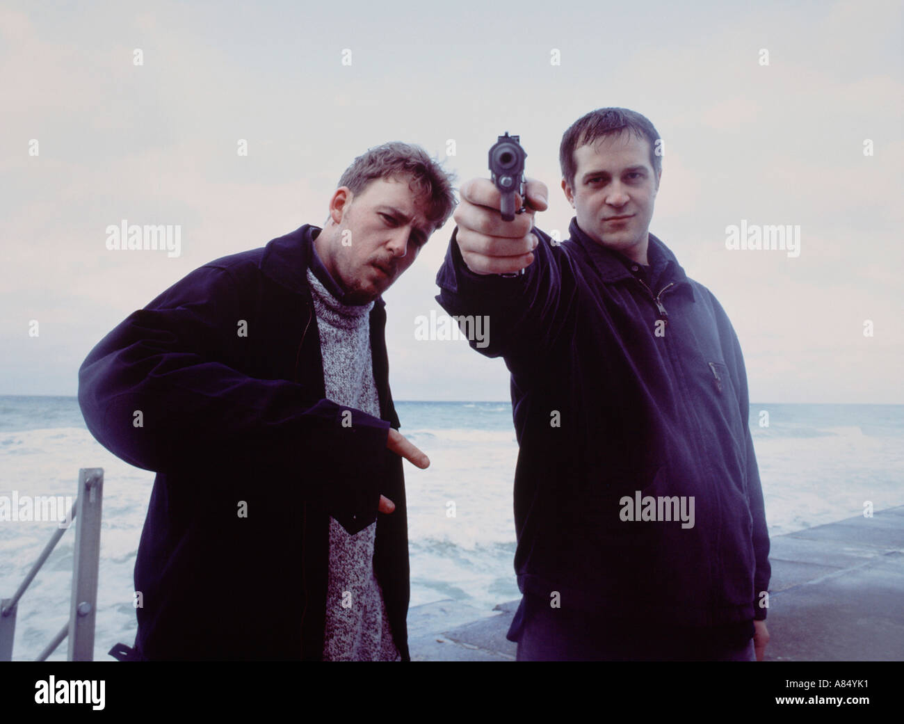 Due uomini pistola di puntamento a telecamera. Foto Stock