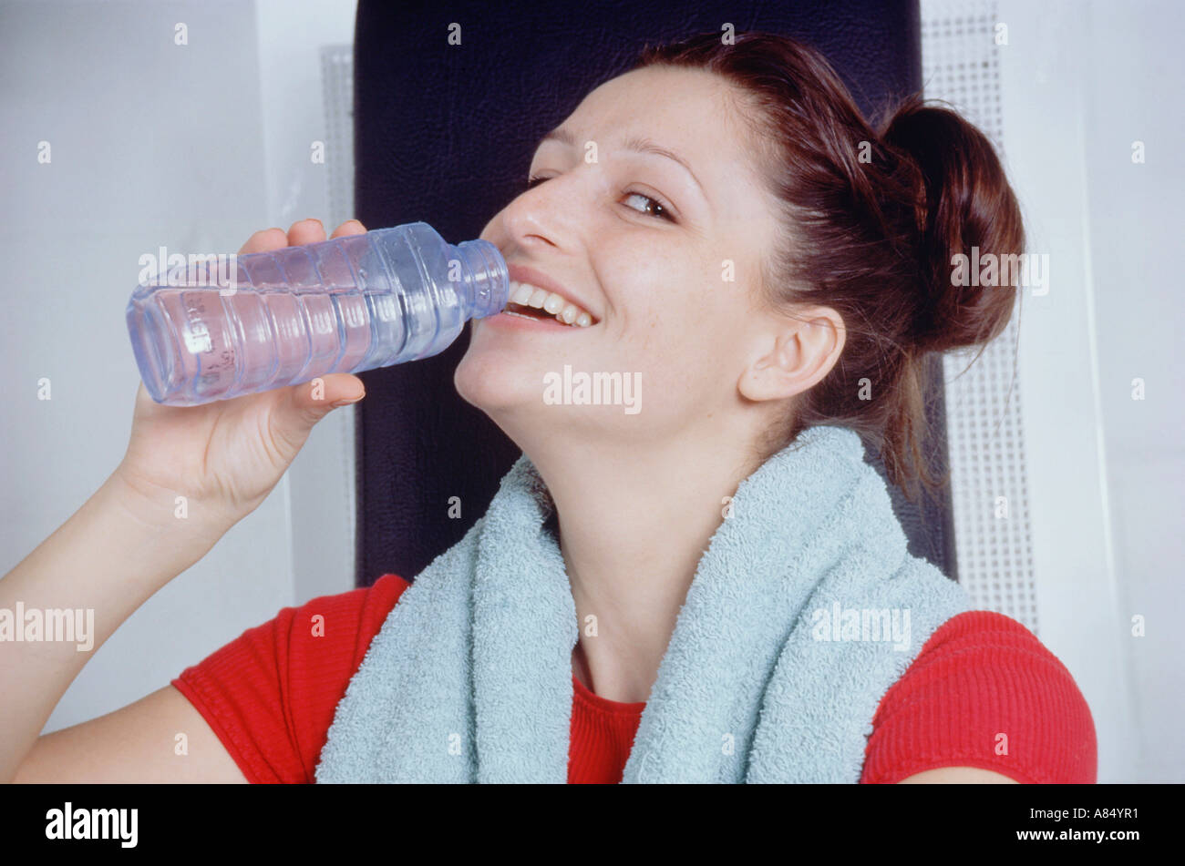 Piscina Ritratto di giovane donna di bere acqua in bottiglia dopo esercizio. Foto Stock