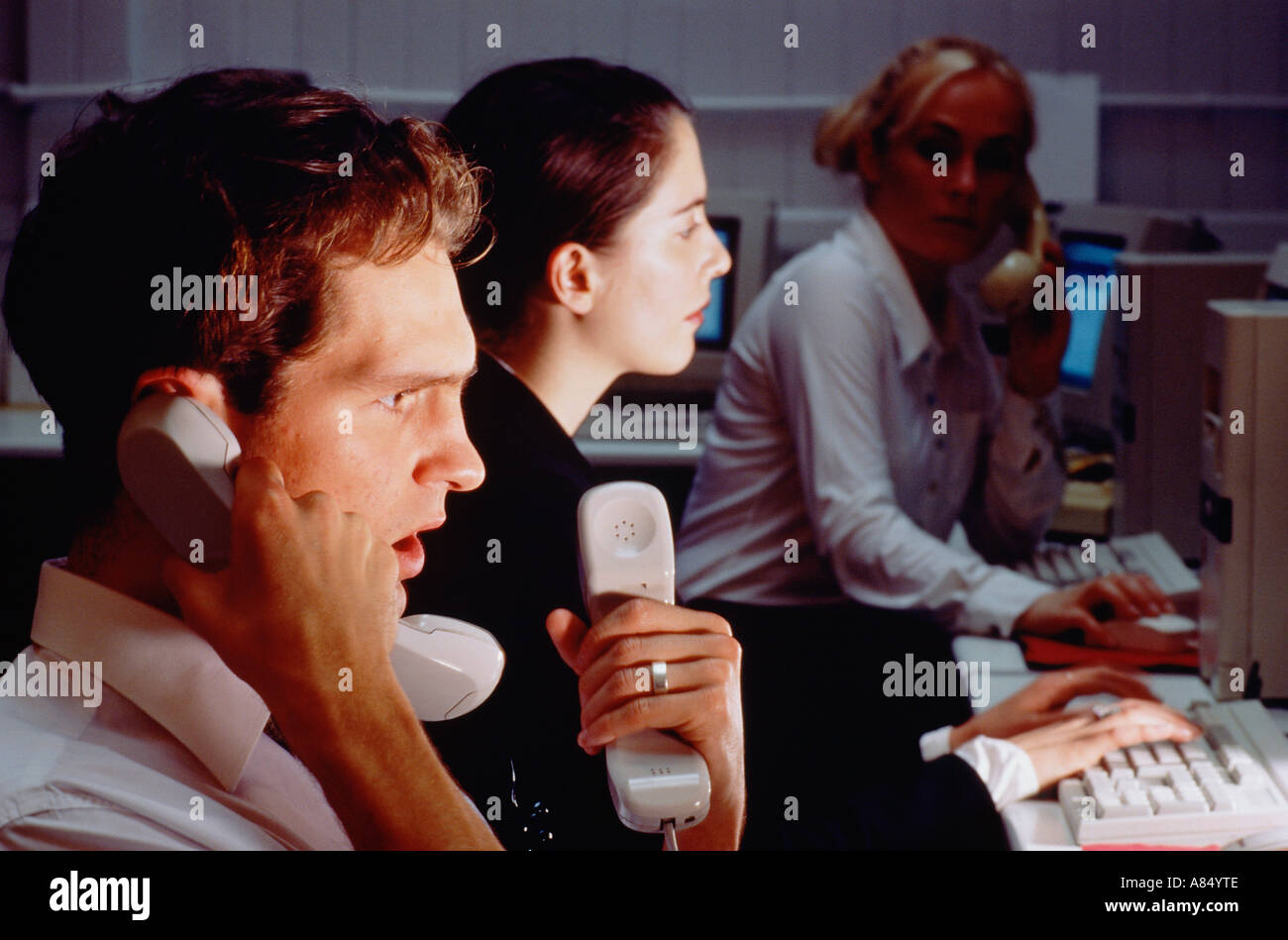 Call center operatori telefonici con computer monitor schermi di notte. Foto Stock