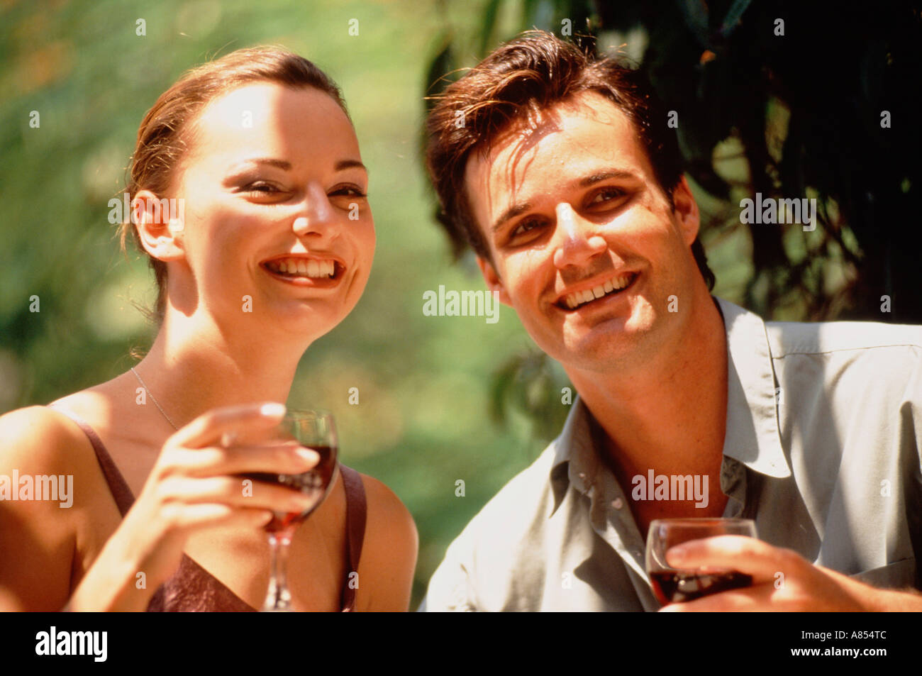 Outdoor ritratto di felice giovane uomo e donna di bere vino rosso. Foto Stock