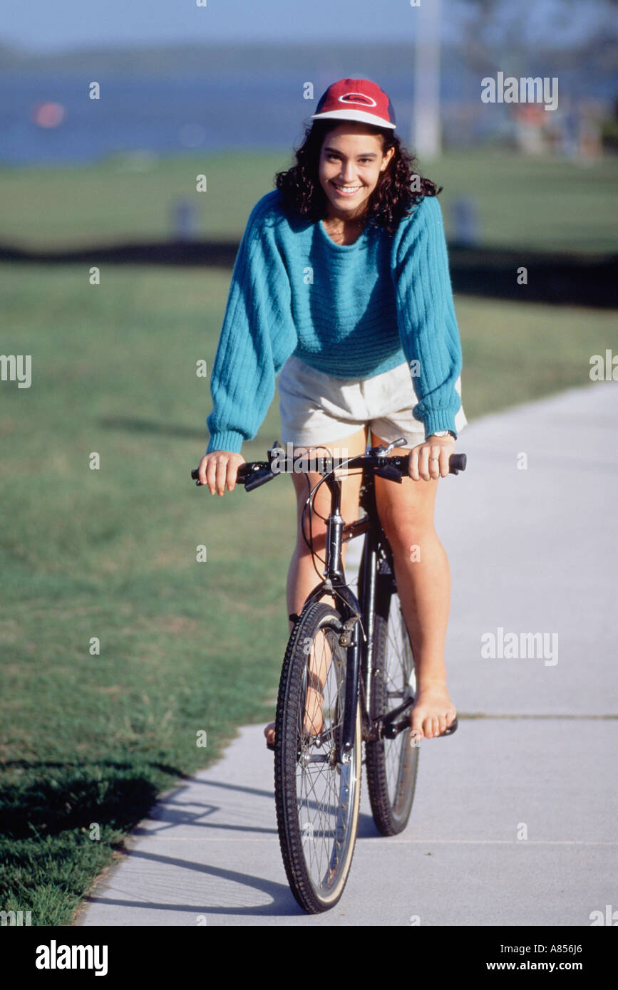 Giovane donna in bicicletta nel waterside park. Foto Stock