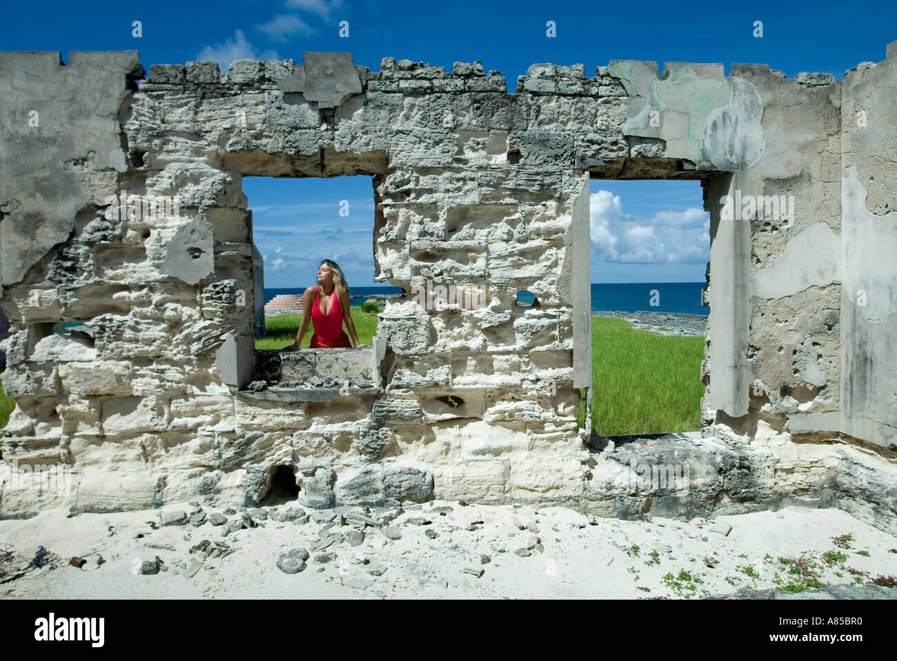 Woman in Red pareo nella costruzione di rovine grande Issac Isola Bahamas Foto Stock