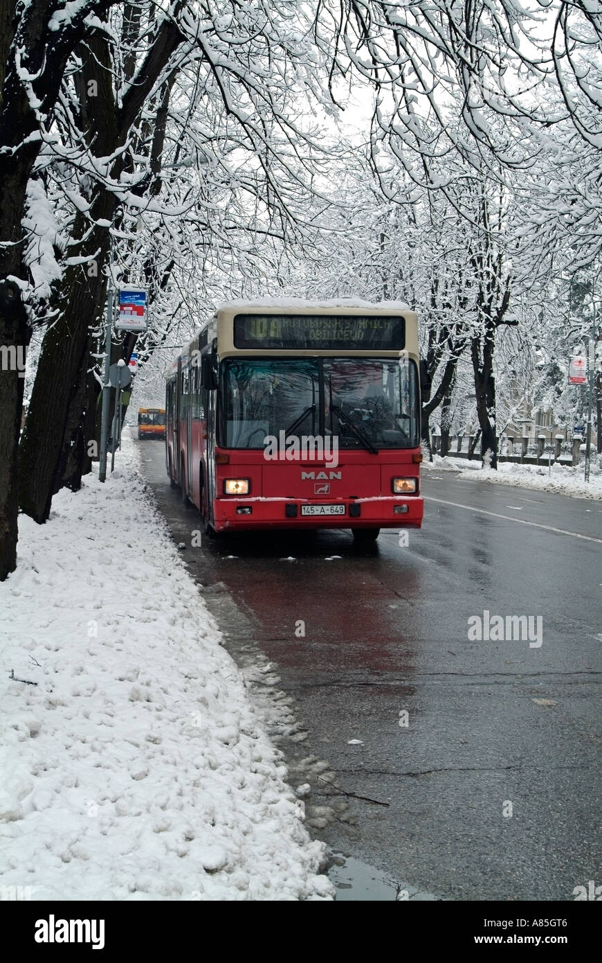 Bus su una strada di città in inverno la neve Foto Stock
